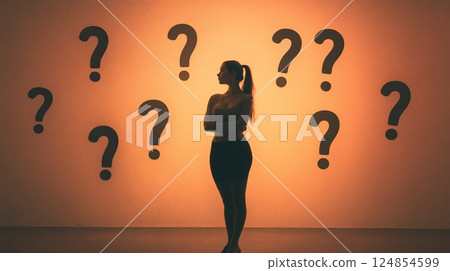 Silhouette of a thoughtful businesswoman making a decision while facing many question marks representing career choices, doubts, and fear of better options 124854599
