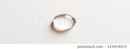 Single, clear water droplet rests on a smooth, light colored surface, reflecting light and creating a subtle distortion, suggesting purity, cleanliness, or scientific themes Single, clear water droplet rests on a smooth, light colored surface, reflecting light and creating a subtle distortion, suggesting purity, cleanliness, or scientific themes 124854672