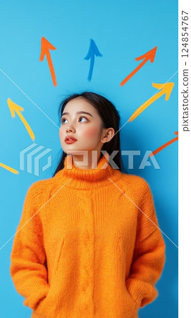 Young woman is looking up at many colorful arrows pointing in different directions, symbolizing choices, opportunities, career path, and decision making 124854767