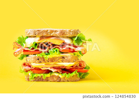 Double bacon, lettuce, tomato sandwich with cheese on yellow Double bacon, lettuce, tomato sandwich with cheese on yellow 124854830