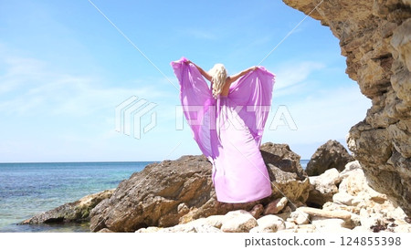 Ocean, Woman, Rocks: Woman with shawl poses among rocks by the sea on a sunny day for artistic expression 124855398