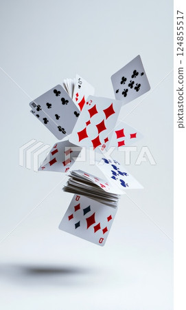 Several playing cards with different suits and values are levitating against a minimalist white backdrop, creating a dynamic and intriguing composition 124855517