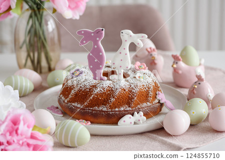 Traditional easter cakes with icing decorated with gingerbread cookies in shape of rabbits on white wooden table Traditional easter cakes with icing decorated with gingerbread cookies in shape of rabbits on white wooden table 124855710