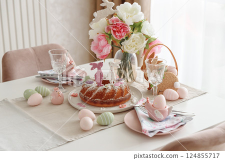Table setting with traditional easter cakes with icing decorated with gingerbread cookies in shape of rabbits on white wooden table Table setting with traditional easter cakes with icing decorated with gingerbread cookies in shape of rabbits on white wooden table 124855717