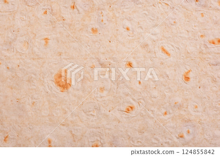 Thin pita bread as a background macro photo. Food background. Thin pita bread as a background macro photo. Food background. 124855842