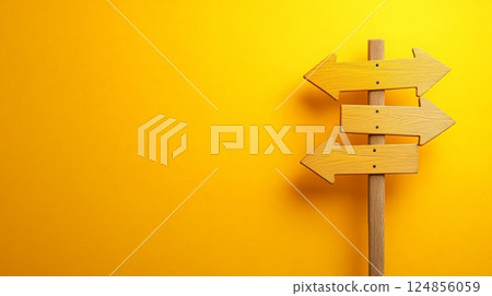 Wooden signpost with three arrows showing different directions on a vibrant yellow background represents choices, decision making, and finding the right path 124856059