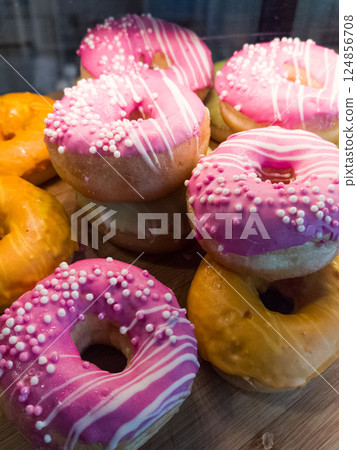 Colorful donuts display on a wooden platter at a festive gathering 124856708