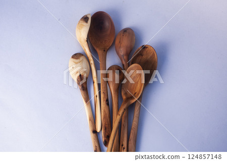 Wooden kitchen utensils stacked view isolated Wooden kitchen utensils stacked view isolated 124857148