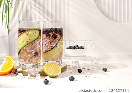 Refreshing summer drink recipe, Cold homemade lemonade or cocktail with chia seeds, blueberries, lemon, cucumber and lime on a sunny table, Detox diet and summer party concept. Restaurant menu 124857584