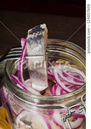 Herring with onions in a glass jar with potatoes 124857609