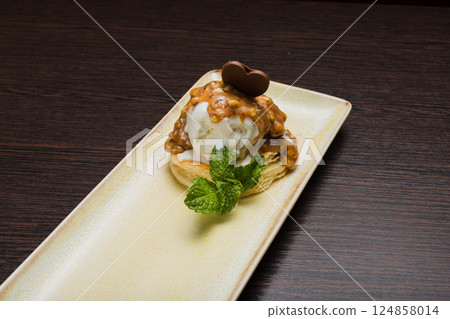 Dessert with puff pastry and ice cream drizzled 124858014