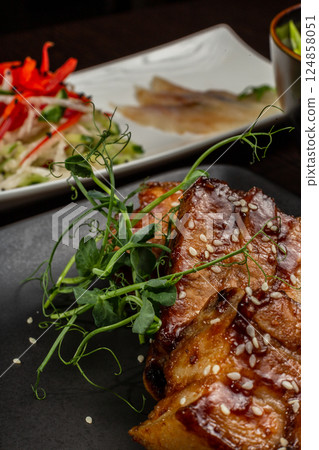 Stewed meat with sesame on a black plate, Japanese Stewed meat with sesame on a black plate, Japanese 124858051