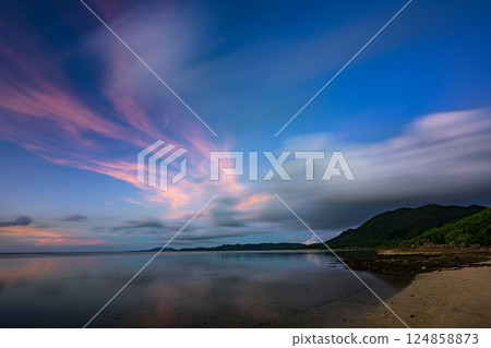 A moving scene of Ishigaki Island with beautiful cloud trails dancing in the evening sky 124858873
