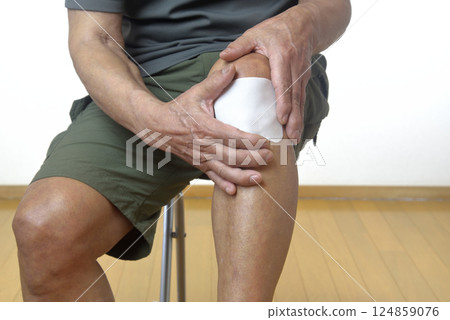 The lower half of a senior who suffers from knee pain The lower half of a senior who suffers from knee pain 124859076