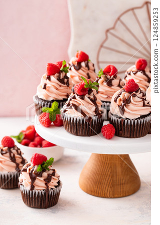 Raspberry chocolate cupcakes with raspberry buttercream frosting a drizzle of chocolate glaze 124859253