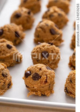 Chocolate chip cookies with pecan nuts, cookie dough ready on a baking sheet 124859268