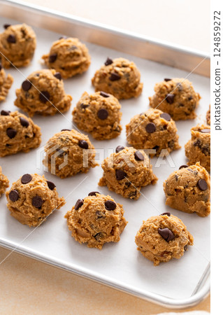 Chocolate chip cookies with pecan nuts, cookie dough ready on a baking sheet Chocolate chip cookies with pecan nuts, cookie dough ready on a baking sheet 124859272