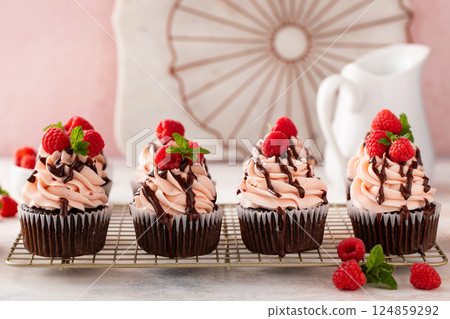 Raspberry chocolate cupcakes with raspberry buttercream frosting a drizzle of chocolate glaze Raspberry chocolate cupcakes with raspberry buttercream frosting a drizzle of chocolate glaze 124859292