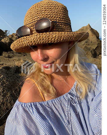 Woman relaxing on rocks by the sea 124859364