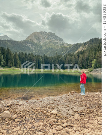 Woman in red windbreaker near the Black Lake in the Durmitor national park Woman in red windbreaker near the Black Lake in the Durmitor national park 124859388