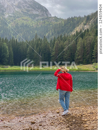 Woman in red windbreaker near the Black Lake in the Durmitor national park Woman in red windbreaker near the Black Lake in the Durmitor national park 124859404