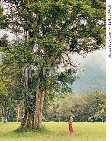 Woman near big tree at beautyful green landscape of Handara Woman near big tree at beautyful green landscape of Handara 124859410