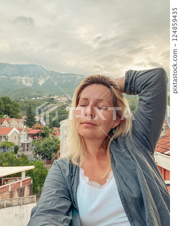 Middle aged woman enjoying stunning mountain view 124859435