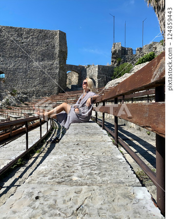 Middle-aged woman relaxing at amphitheater of Kanli Kula Fortress Middle-aged woman relaxing at amphitheater of Kanli Kula Fortress 124859443