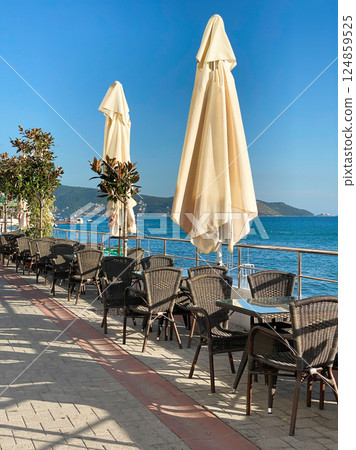 Empty restaurant tables on the embankment resort town Herceg Novi Empty restaurant tables on the embankment resort town Herceg Novi 124859525