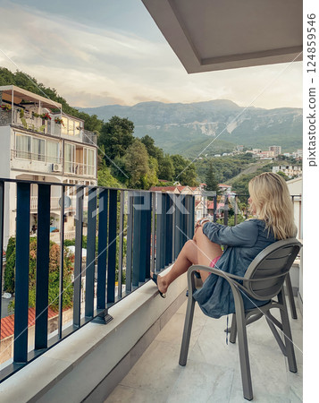 Middle-aged woman relaxing in a chair on a balcony Middle-aged woman relaxing in a chair on a balcony 124859546