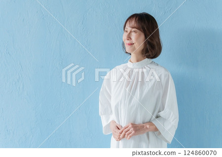 微笑的中年婦女（藍色背景） 124860070