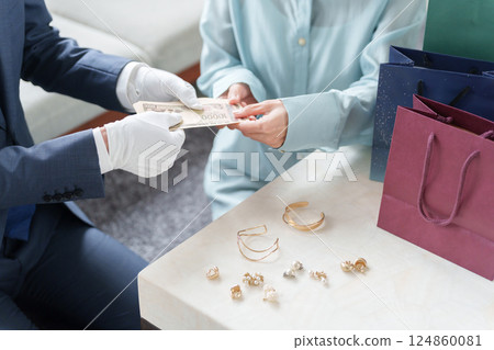 A mobile used buyer assessing the items with a female customer 124860081