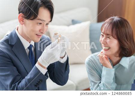 A mobile used buyer assessing the items with a female customer A mobile used buyer assessing the items with a female customer 124860085