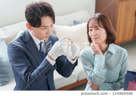A mobile used buyer assessing the items with a female customer A mobile used buyer assessing the items with a female customer 124860086