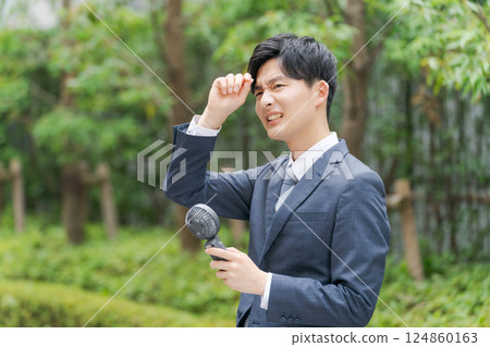 一位拿著手持風扇的年輕上班族 124860163
