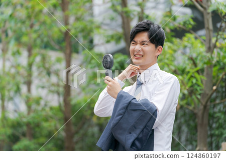 Summer businessman holding a handy fan 124860197