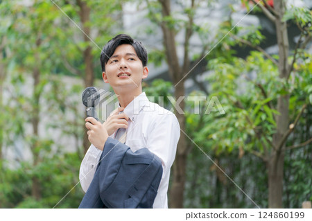 Summer businessman holding a handy fan 124860199
