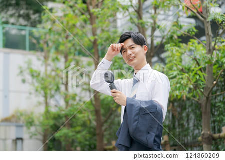夏季商人拿著一把方便的風扇 夏季商人拿著一把方便的風扇 124860209