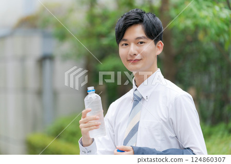 Office worker drinking water in the park 124860307