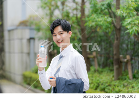 Office worker drinking water in the park Office worker drinking water in the park 124860308