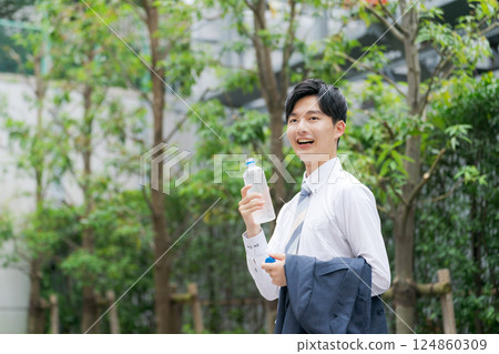 Office worker drinking water in the park 124860309