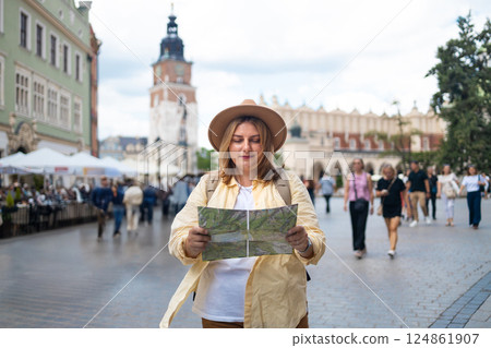 Woman in a city square holding a map, exploring the surroundings Woman in a city square holding a map, exploring the surroundings 124861907