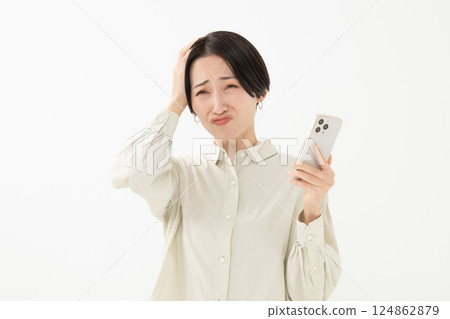 看著智能手機屏幕的驚訝的女人 看著智能手機屏幕的驚訝的女人 124862879