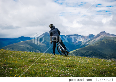 Riding mountain bike on grassland mountain top 124862981