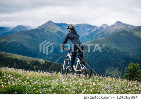 Riding mountain bike on grassland mountain top 124862984