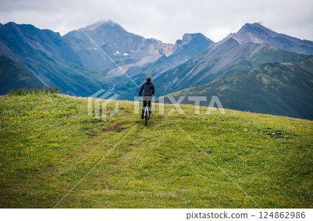 Riding mountain bike on grassland mountain top 124862986