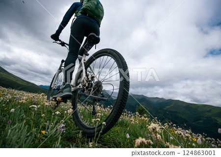 Riding mountain bike on grassland mountain top 124863001
