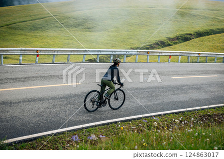 Riding bike on grassland mountain top trail 124863017