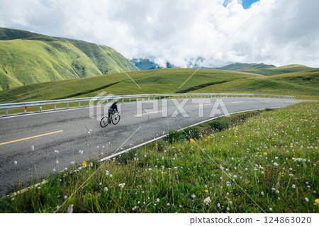 Riding mountain bike on grassland mountain top 124863020