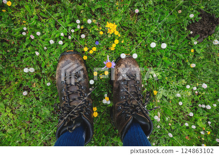 Hiker legs walking on beautiful flowering grassland Hiker legs walking on beautiful flowering grassland 124863102